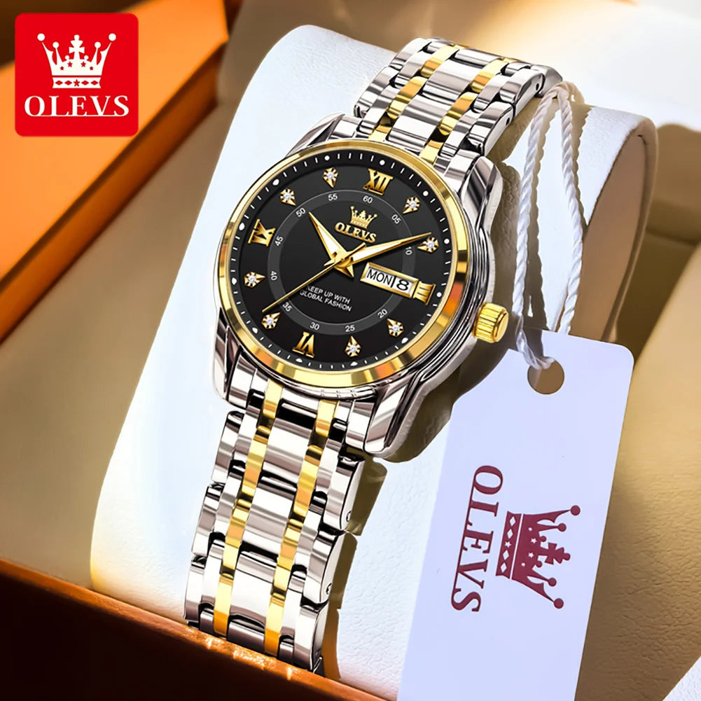 A stainless steel watch with a black face and gold accents is displayed in a box with a white tag.