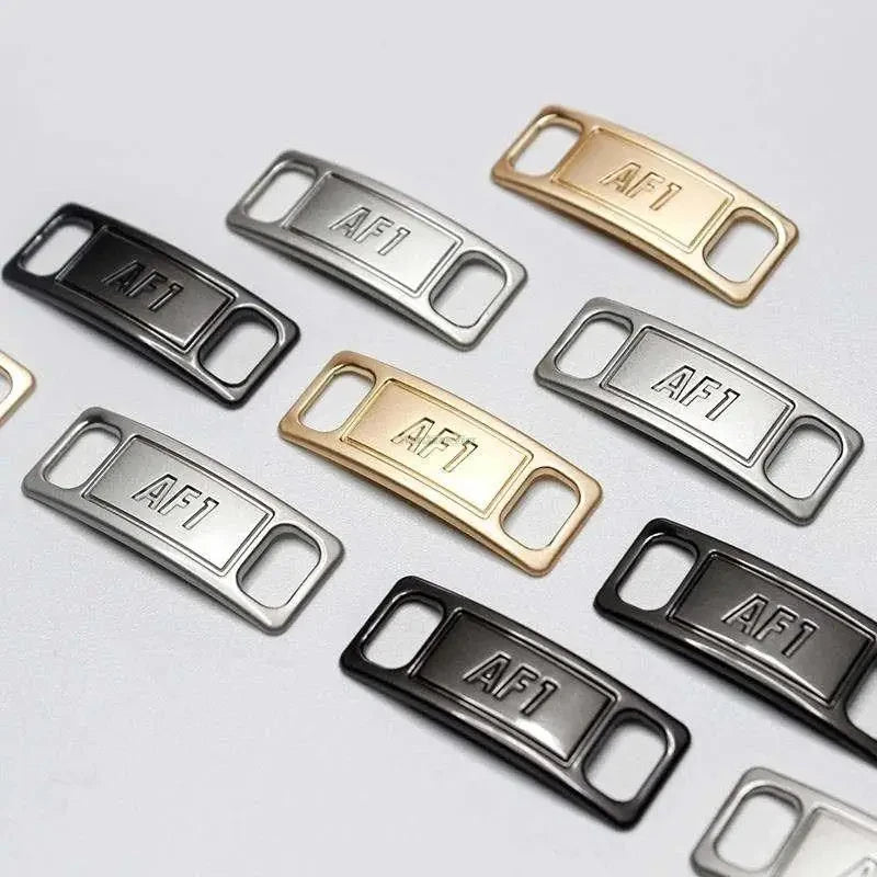 A collection of gold and silver metal shoe charms and laces marked with the letters AF1