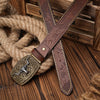 A brown PU leather floral engraved belt is laid across a wooden surface next to thick rope.