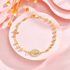 A delicate 18K gold plated rosary bracelet for women displayed on a pink background.