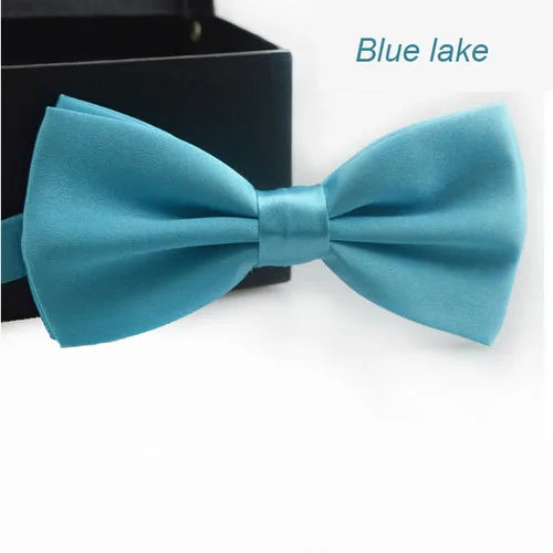 Nœud papillon satin bleu sarcelle affiché sur fond sombre.