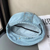 A light blue retro washed cotton denim beret hat with a stitched leather patch detail.
