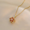 Collier en or avec pendentif fleur de zircon aux pierres roses et rouges.