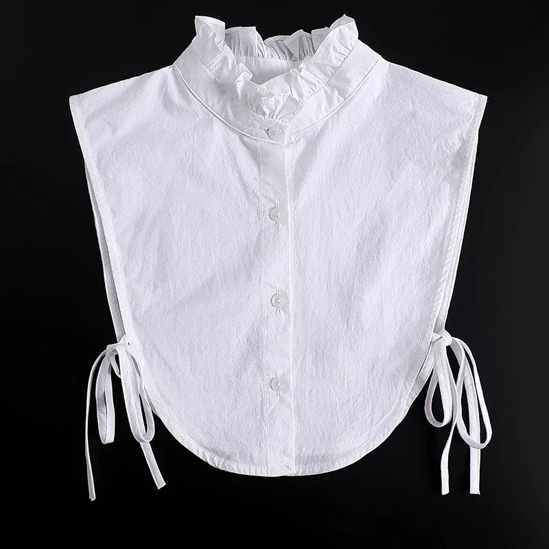 White blouse with a ruffled false collar and tie details.