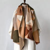 A beige and brown plaid cashmere scarf draped over a mannequin.