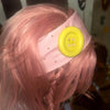 A pink hair styled in braids wears a light pink headband with a yellow polka dot button detail.