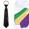 A set of three sequin ties in black, green, and gold laid out on a white shirt.