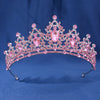 A pink crystal rhinestone tiara and headband set with intricate floral designs.
