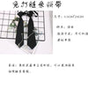 A black chain necktie accessory is shown, pre-tied and adjustable, suitable for school uniforms.