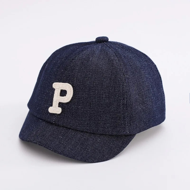A dark navy denim baseball cap with a light beige letter P embroidered on the front.