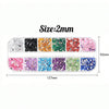 A set of four colored rhinestones for nail art decoration, showing various shades including black, orange, green, and pink.