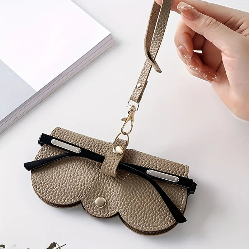 A tan PU leather pouch and glasses case with a leather strap is shown against a white background.