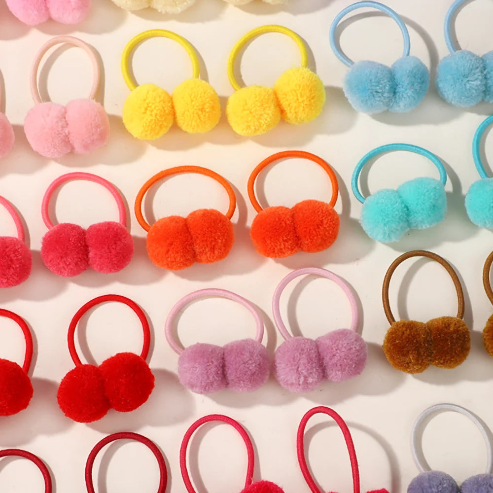 A collection of colorful double plush elastic hair bands in pink, yellow, orange, and blue.