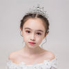A young girl wearing a sparkling crystal princess tiara hair comb and white dress.
