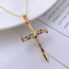A dainty gold cross charm necklace featuring colorful gemstones on a delicate chain.