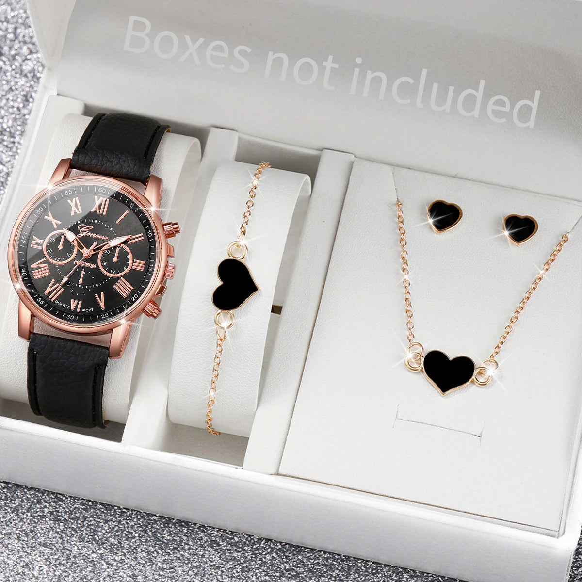 A watch box contains a rose gold quartz wristwatch and a gold necklace with black heart pendants.
