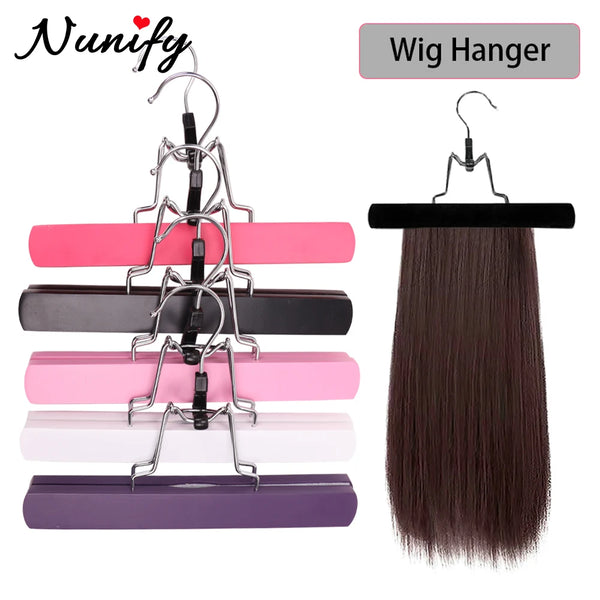 A set of pink, purple, and black wooden wig hangers and a dark brown hair extension.