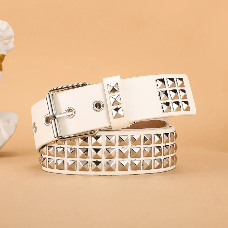 A beige leather belt featuring silver metal rivets and studs, shown flat on a neutral background.
