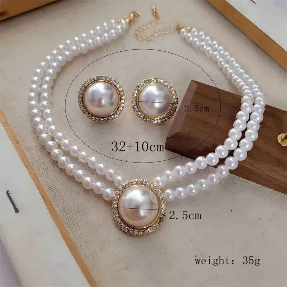 Collier et boucles d'oreilles de perles blanches assortis, présentés sur une surface en bois.