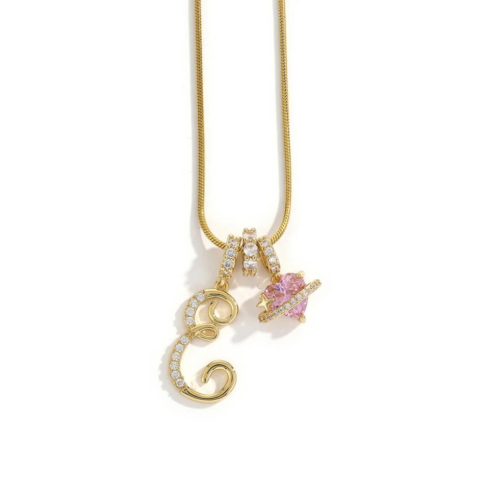 A gold-toned alphabet flower pendant necklace with a pink gemstone charm.