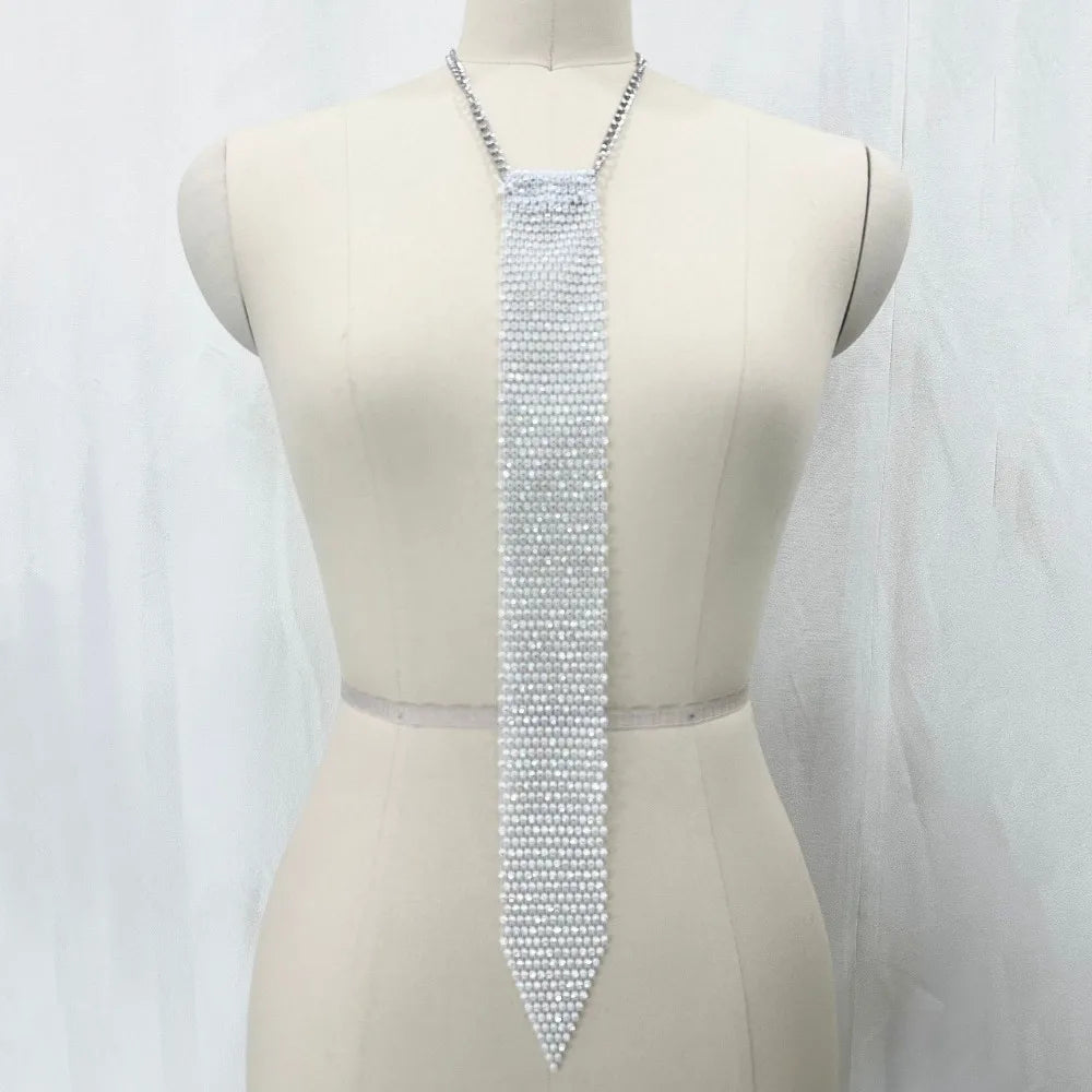 A long, silver crystal rhinestone sequin necklace displayed on a mannequin's neck.
