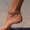 Gold plated minimalist Cuban link anklet worn on a woman's ankle.