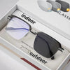 Une paire de lunettes de soleil sombres dans une boîte ouverte avec des étiquettes pour usage intérieur et extérieur.