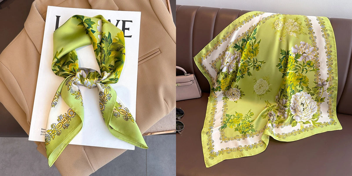 A light green floral print silk scarf tied in a bow displayed on a white card against a tan blazer.