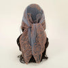 A dark gray floral embroidered lace bandana headscarf tied around a person's hair.