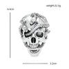 Broche calavera de pedrería plateada con diseño detallado de cráneo humano.