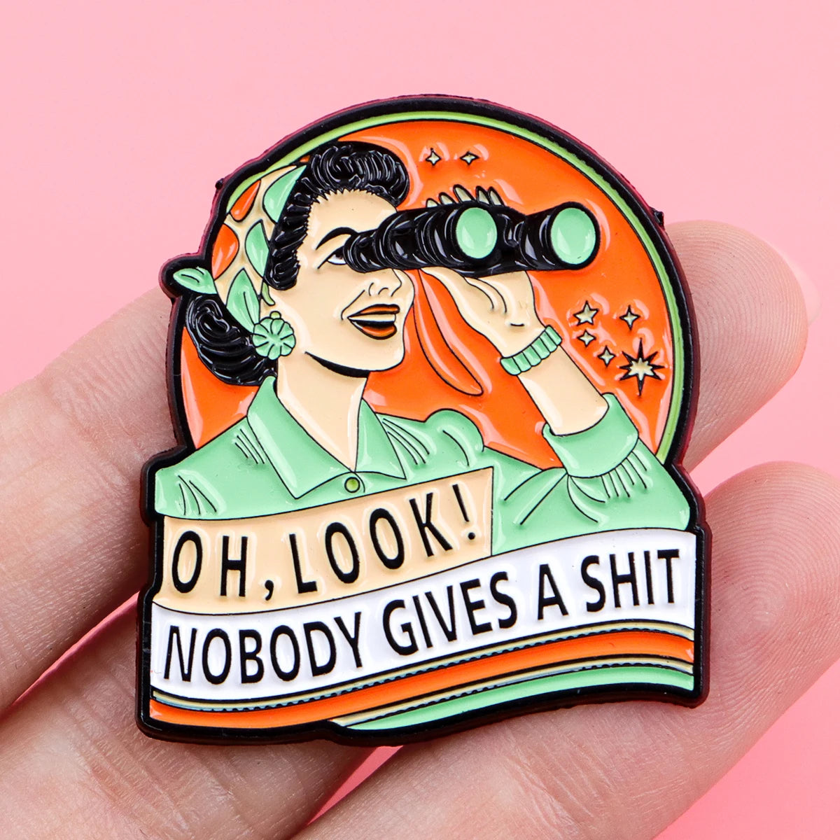 An enamel pin featuring a stylized character looking through a telescope with text that reads Oh look nobody gives a shit