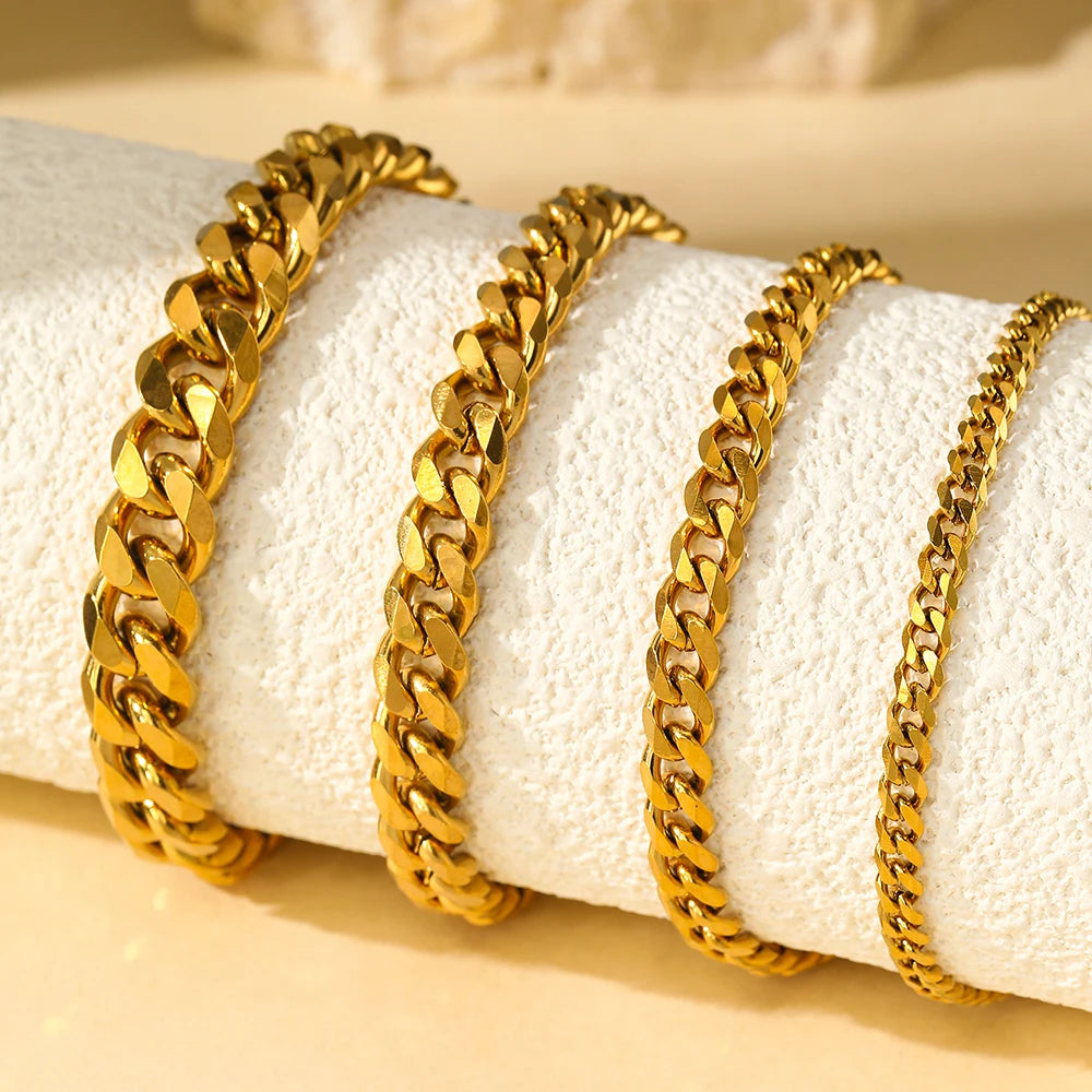 Gold stainless steel multi-chain anklets displayed on a white towel.