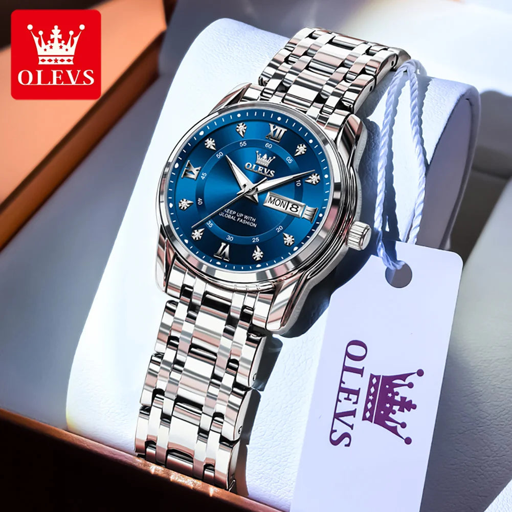 A stainless steel watch with a blue dial and crown is displayed in a box with a white tag.