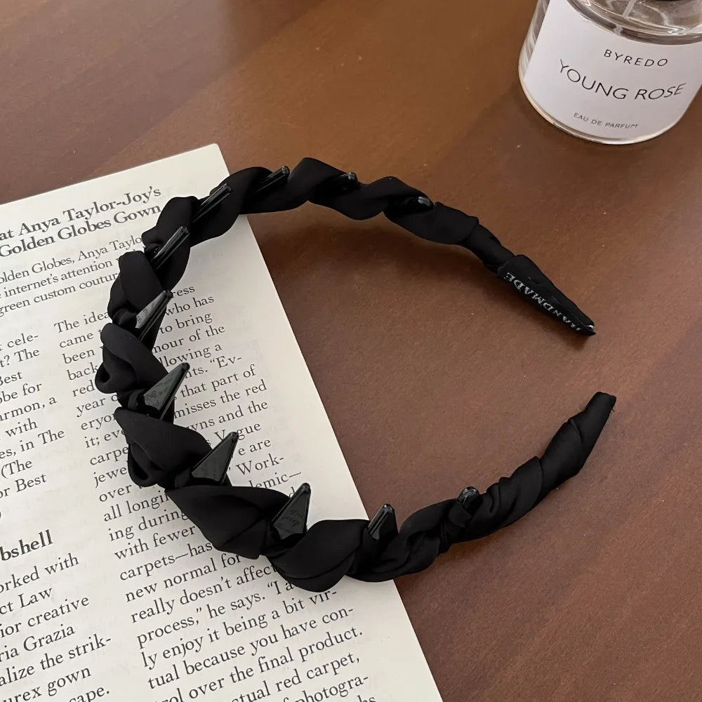 Black chic knotted hair headbands with teeth displayed on a white paper background