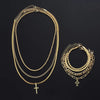 A gold-toned stainless steel cross jewelry set featuring multiple layered chains and pendants.