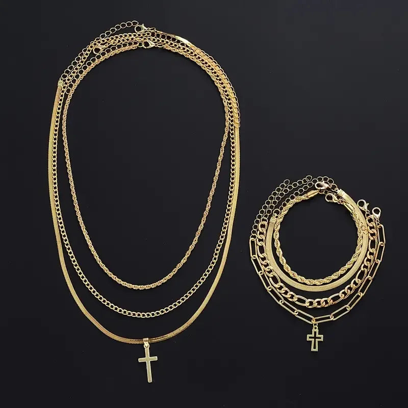 A gold-toned stainless steel cross jewelry set featuring multiple layered chains and pendants.