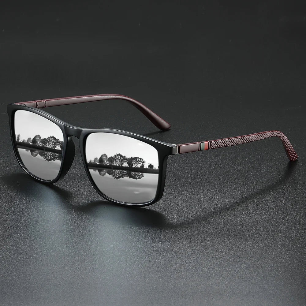 A pair of vintage square polarized cycling sunglasses with dark frames and brown accents resting on a dark surface.