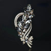 Broche florale en cristal élégante avec des feuilles et pétales argentés délicats.