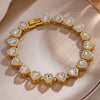 A gold-toned stacking bracelet set featuring multiple heart-shaped clear rhinestones on a neutral background.