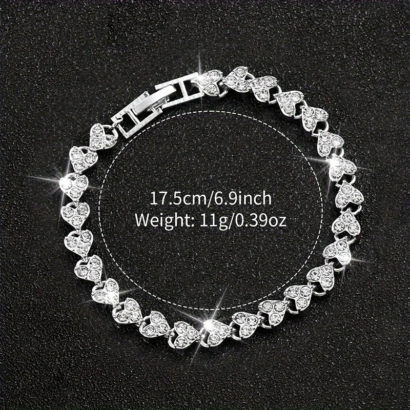 A silver rhinestone heart watch set is displayed on a black background.