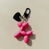 A pink jelly cartoon dog keychain with a black charm and silver chain.
