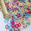 A colorful assortment of nylon elastic hair cords in various shades of pink, blue, yellow, and purple.