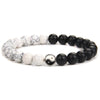 A black and white Yin Yang hand string bracelet made of smooth beads.