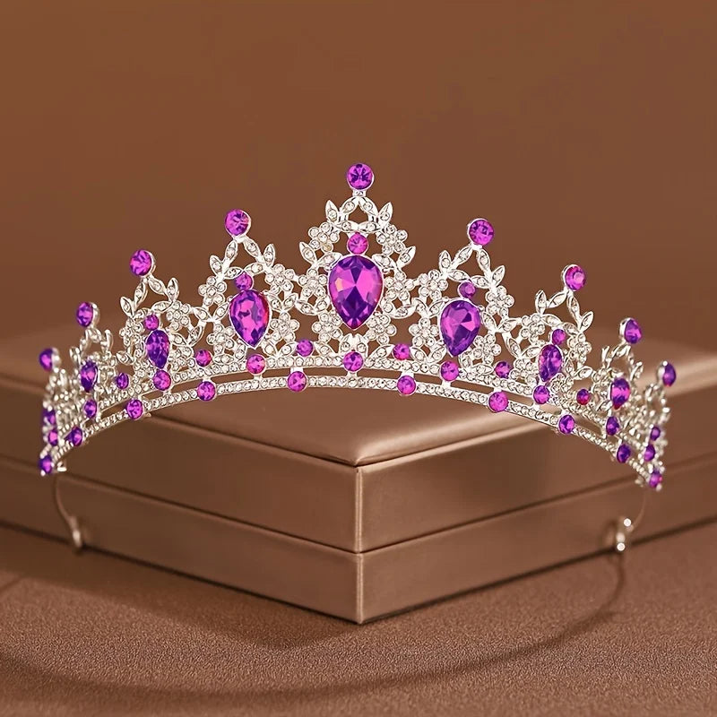 Diadema de cristal púrpura brillante y transparente con intrincado diseño barroco, exhibida en una caja.