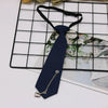 A dark blue necktie with a gold chain and clip is displayed on a black grid background.