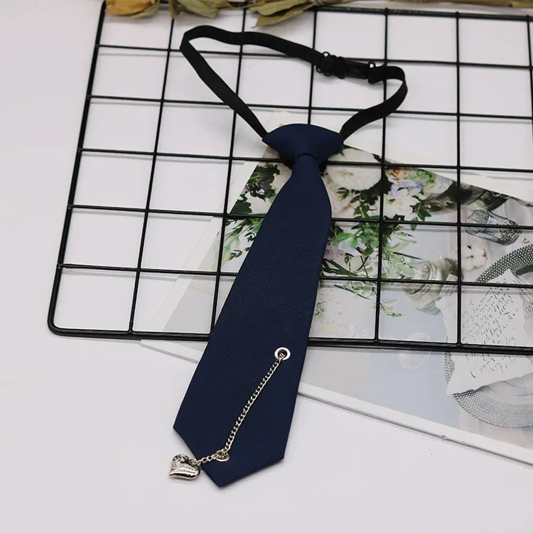 A dark blue necktie with a gold chain and clip is displayed on a black grid background.