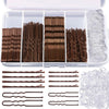 A set of brown hair and clear bobby pins displayed in an open plastic container with loose pins outside.