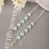 A delicate pearl beaded eyewear chain featuring light blue beads and gold accents.