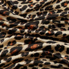 Fließender Stoff mit Leopardenmuster in Schwarz-, Braun- und Beige-Tönen.