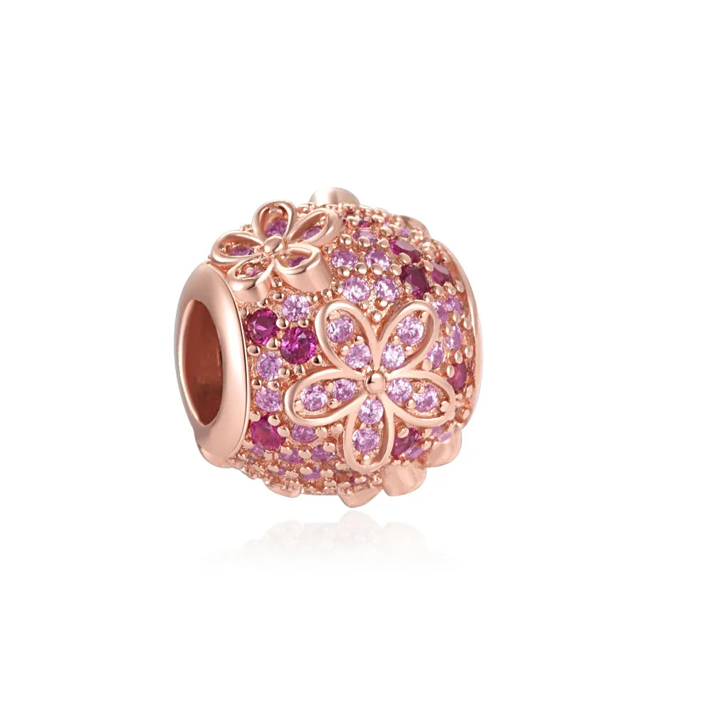 Rose gold charm pendant shaped like a flower with pink and purple stones.